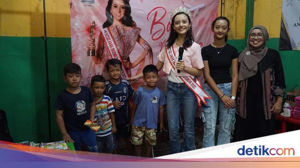 Audellya Ambara tersenyum bersama anak-anak saat membagikan buku bacaan.