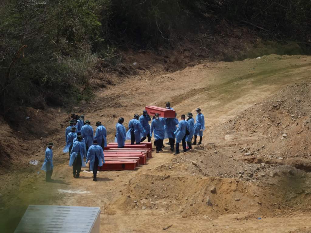 Petugas forensik dan alat berat menyiapkan pemakaman massal bagi korban gempa